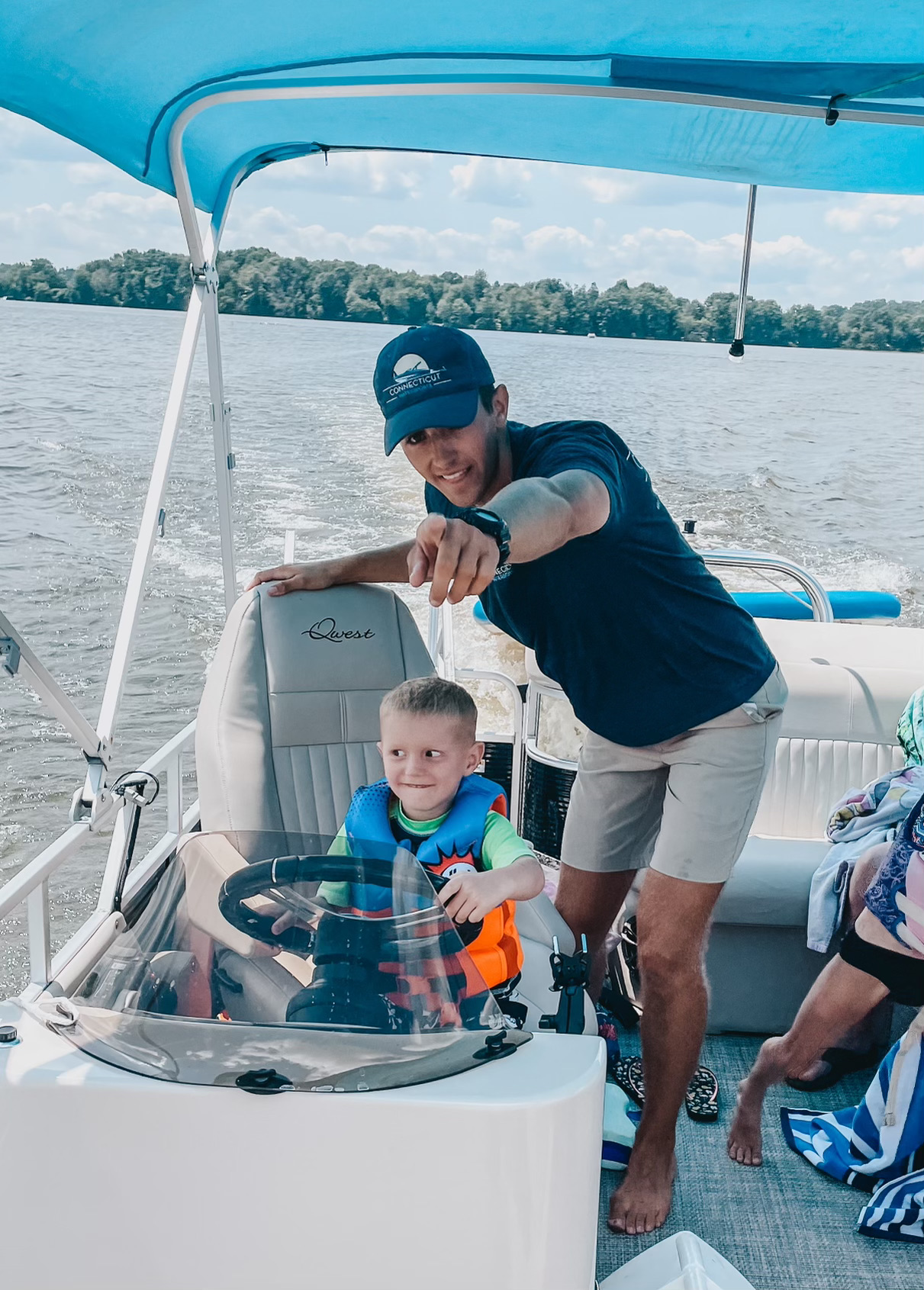 A CT Water Sports captain coaching a young guest at the helm on Lake Lillinonah
